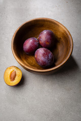 Organic fresh plums on concrete