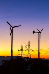 Obraz premium Future of Renewable Energy. Wind Turbines High Voltage Plantation at Sunset