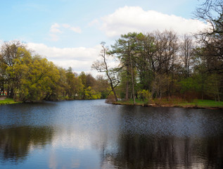 Landscape of river flows through the park with yellow green trees and blue sky