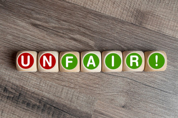 Würfel mit dem Begriff Unfair und Fair