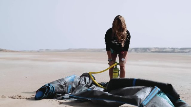 Young Woman Pumping Air into Kite