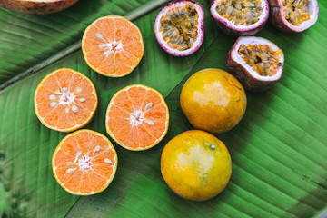 Cut half fresh Oranges and Passion Fruits on banana leaves. Example taste of coffee. Fruity and Sour.