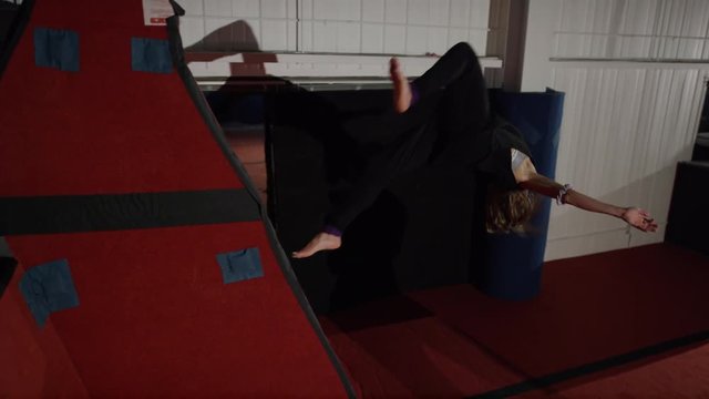 Female gymnast training in the gym for parcour and trampoline