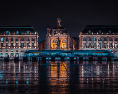 Modern city tramway during night front of Place de la Bourse at Bordeaux