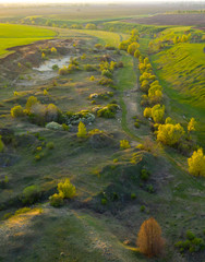 Spring fields, meadows, ravines at sunset from the quadrocopter
