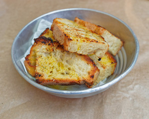 sliced bread roasted with vorgin olive oil and oregano in metalic dish