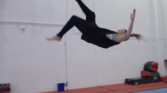 Female gymnast training in the gym for parcour and trampoline