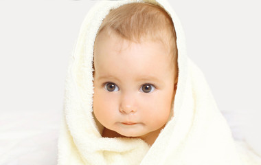 Portrait close-up face cute baby under towel on background