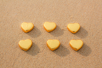 Chocolate color Lovely golden heart on the beach. Background is a natural in real place, creative Valentine's Day Concept, tropical style background made in Phuket, Thailand.