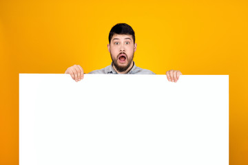bearded surprised man holding a banner for text, expressive shouts and inviting buyers