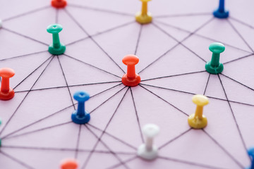 selective focus of push pins connected with strings Isolated On pink, network concept