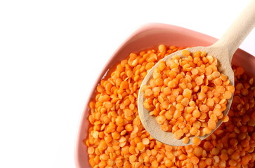 Red lentils with bowl  and wooden spoon isolated on white