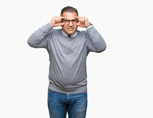 Fototapeta premium Middle age bussines arab man wearing glasses over isolated background Trying to open eyes with fingers, sleepy and tired for morning fatigue