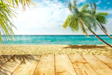 Wooden table background of free space and summer beach with palms. 
