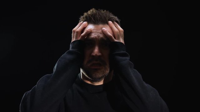 Mentally ill patient suffering hallucinations on black background, panic attack
