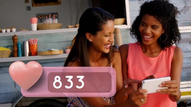Black women laughing while looking at their phone