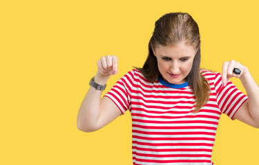 Middle age mature woman wearing casual t-shirt over isolated background Pointing down with fingers showing advertisement, surprised face and open mouth