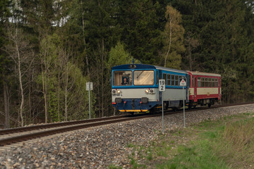 Fototapeta premium Blue and red diesel train with passengers coach in Jeseniky mountains