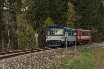 Blue and red diesel train with passengers coach in Jeseniky mountains