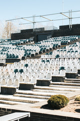 Stadium stands with aisles and white and gray plastic seats
