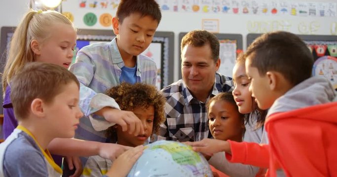 Front view of Caucasian male teacher teaching the kids about the globe in the classroom 4k