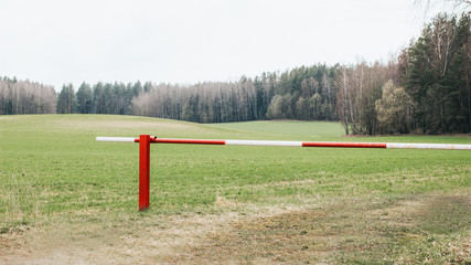 Fototapeta na wymiar Closed red and white barrier at forest entrance