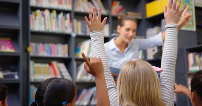 Caucasian female teacher teaching schoolkids in the school library 4k