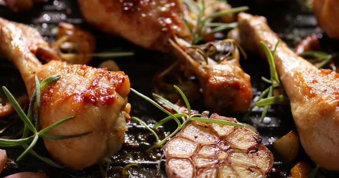 Grilled chicken. Grilled chicken legs, drumsticks with addition, garlic, lemon and rosemary on grill plate. Grill food, 4k