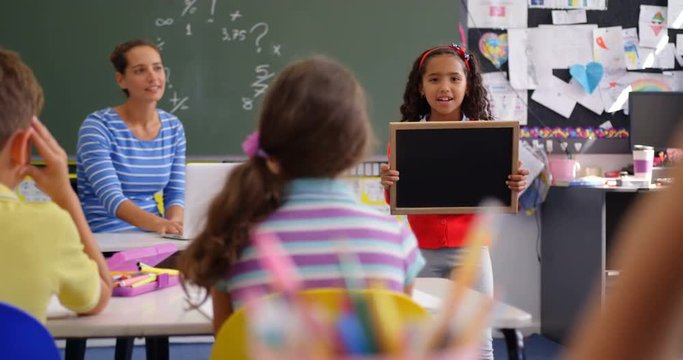 Front view of African american schoolgirl explaining about slate in the classroom 4k