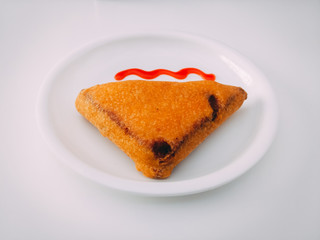 Bread Pakoda with tomato sauce. Indian tea time snack prepared from Potatoes and chillies. A common street food or fast food snack. deep fried in vegetable oil