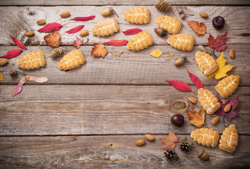 cookies and autumn leaves on  wooden background