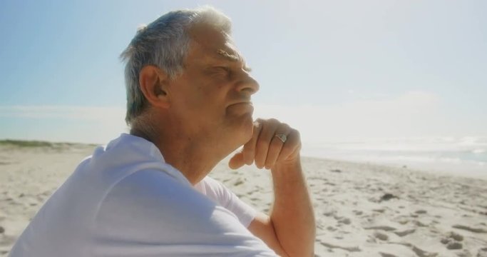 Side view of active senior Caucasian man relaxing on the beach 4k