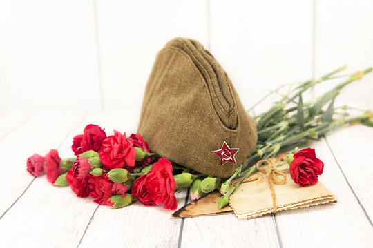 Victory Day. May 9. Red carnations, old photos and forage-cap