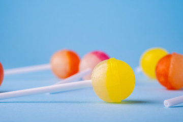 Close up lollipop candies on blue background angle view