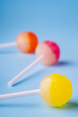 Close up lollipop candies on blue background angle view