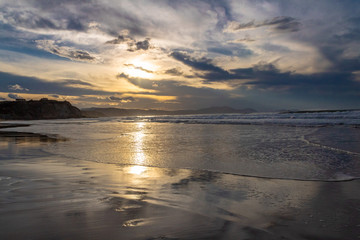sunset on the beach of Atxabiribil, Sopelana, vizcaya. The sun is reflected on the seashore