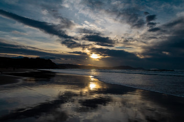 sunset on the beach of Atxabiribil, Sopelana, vizcaya. The sun is reflected on the seashore