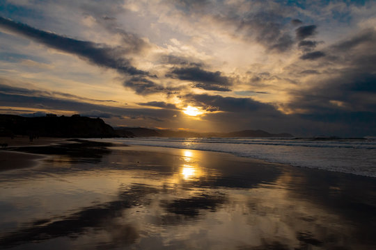 sunset on the beach of Atxabiribil, Sopelana, vizcaya. The sun is reflected on the seashore © iker