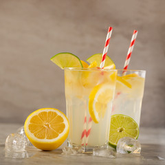 two glasses of lemonade with lemons and lime and straw, a cool drink and summer mood, with ice