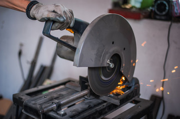 Cutting metal with grinder in workshop. Sparks while grinding iron. Cutting machine