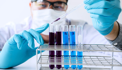 Biochemistry laboratory research, Scientist or medical in lab coat holding test tube with reagent...