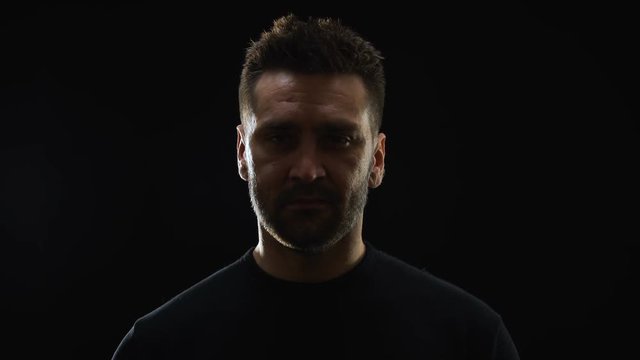 Dangerous male criminal smirking on camera, maniac thinking of murder, revenge