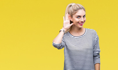 Young beautiful blonde woman wearing stripes sweater over isolated background smiling with hand...