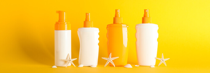 Sunscreen sprays with starfishes on color background, space for text. Safe tan accessories