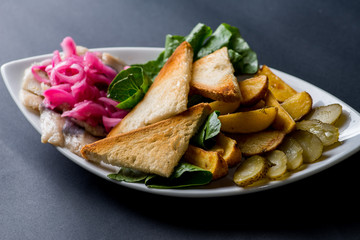 Snack  made from potatoes, herring and pickled vegetables
