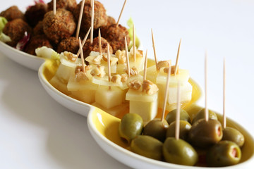 Finger food, antipasto con formaggio, polpettine e olive isolate su sfondo bianco