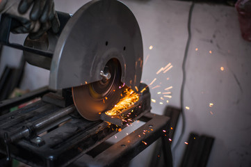 Cutting metal with grinder in workshop. Sparks while grinding iron. Cutting machine