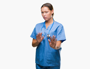 Young caucasian doctor woman wearing medical uniform over isolated background disgusted expression,...