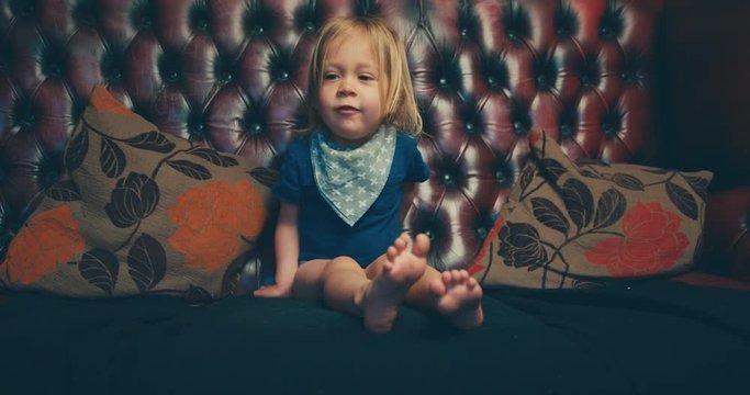 Little toddler getting down from the sofa