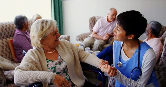 Front view of Asian female doctor interacting with senior woman at nursing home 4k